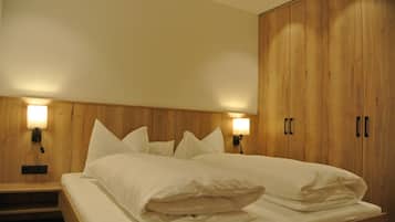 Un dormitorio con cabecera de madera, dos lámparas de noche y un armario grande.