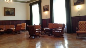 Una stanza con pannelli in legno, un lampadario e diverse poltrone in pelle.