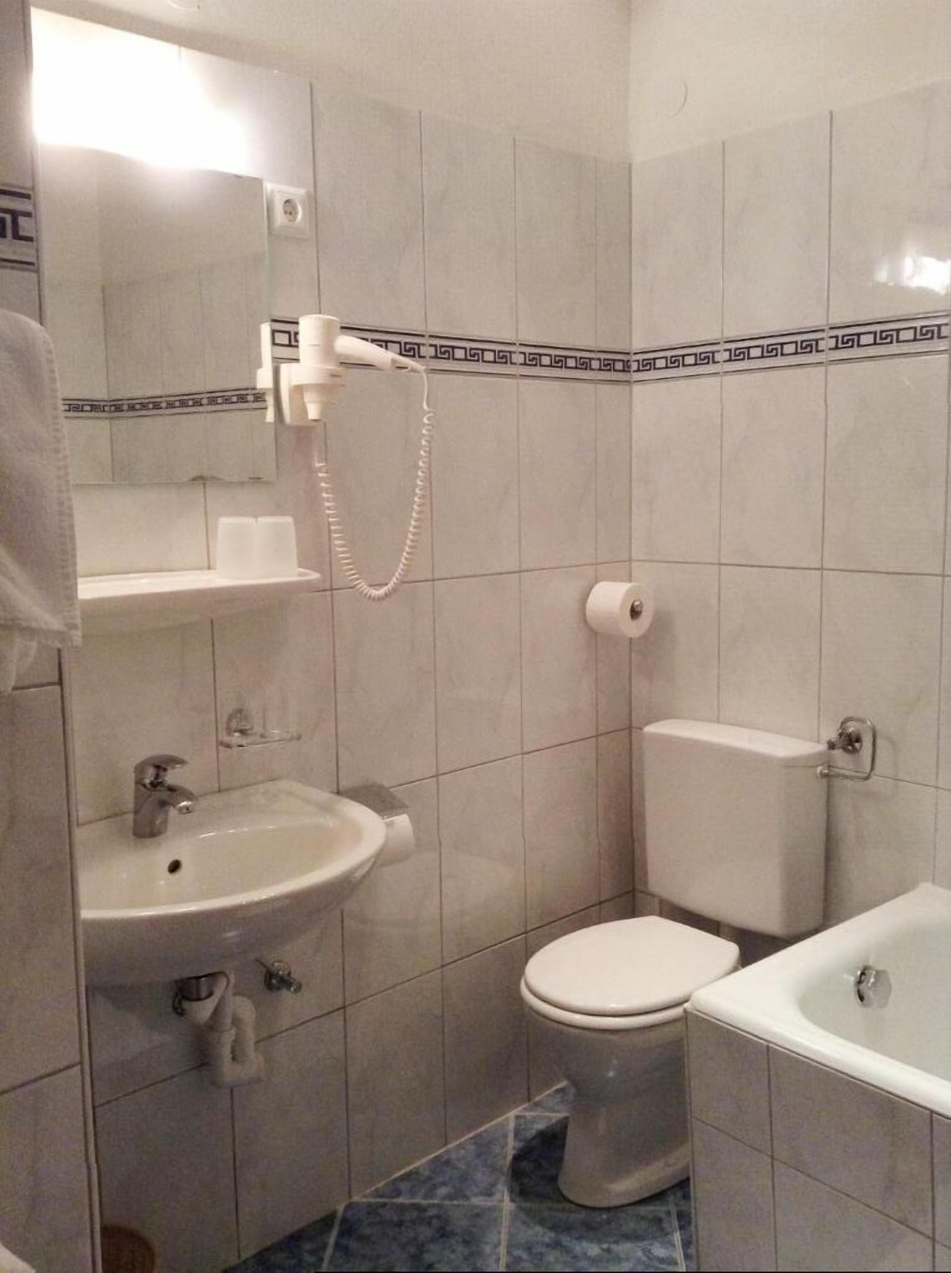 A bathroom with a toilet, bidet, and sink.