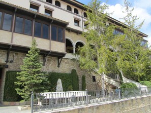 A multi-story building with a stone facade, arched windows, and a staircase leading to an upper level. - Hotel & Spa Balfagón (Cantavieja)