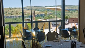 A dining area with a table set for two, overlooking a scenic landscape. - Hotel & Spa Balfagón (Cantavieja)