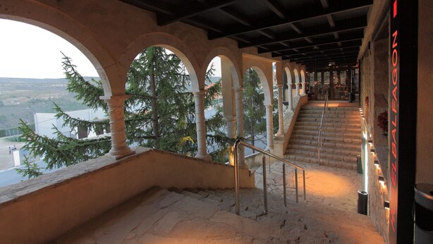 A staircase with stone steps and metal railings, leading to a higher level with a view of trees and a distant landscape. - Hotel & Spa Balfagón (Cantavieja)