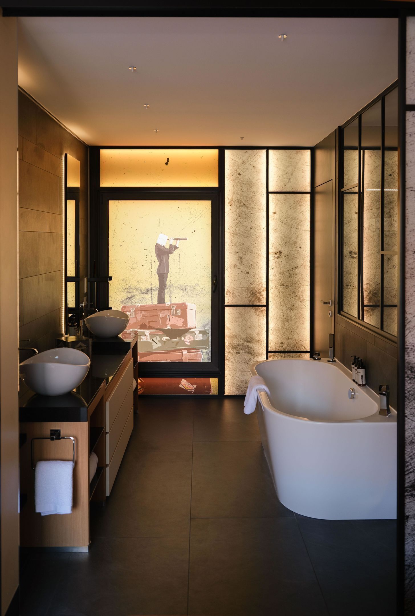A modern bathroom with a freestanding bathtub, a double sink vanity, and a large mirror.