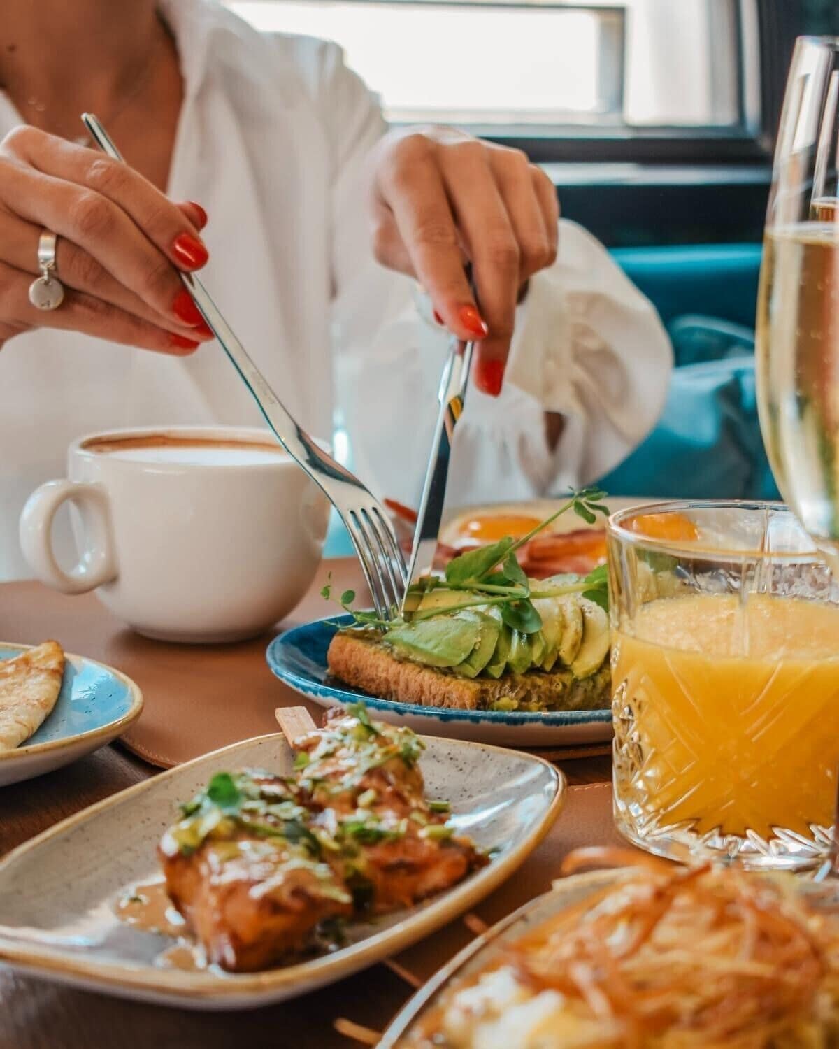 Ein Esstisch mit verschiedenen Speisen, einer Kaffeetasse und einem Glas Orangensaft.