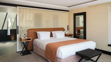 Een hotelkamer met een groot bed, een nachtkastje, een spiegel en uitzicht op het omliggende landschap.