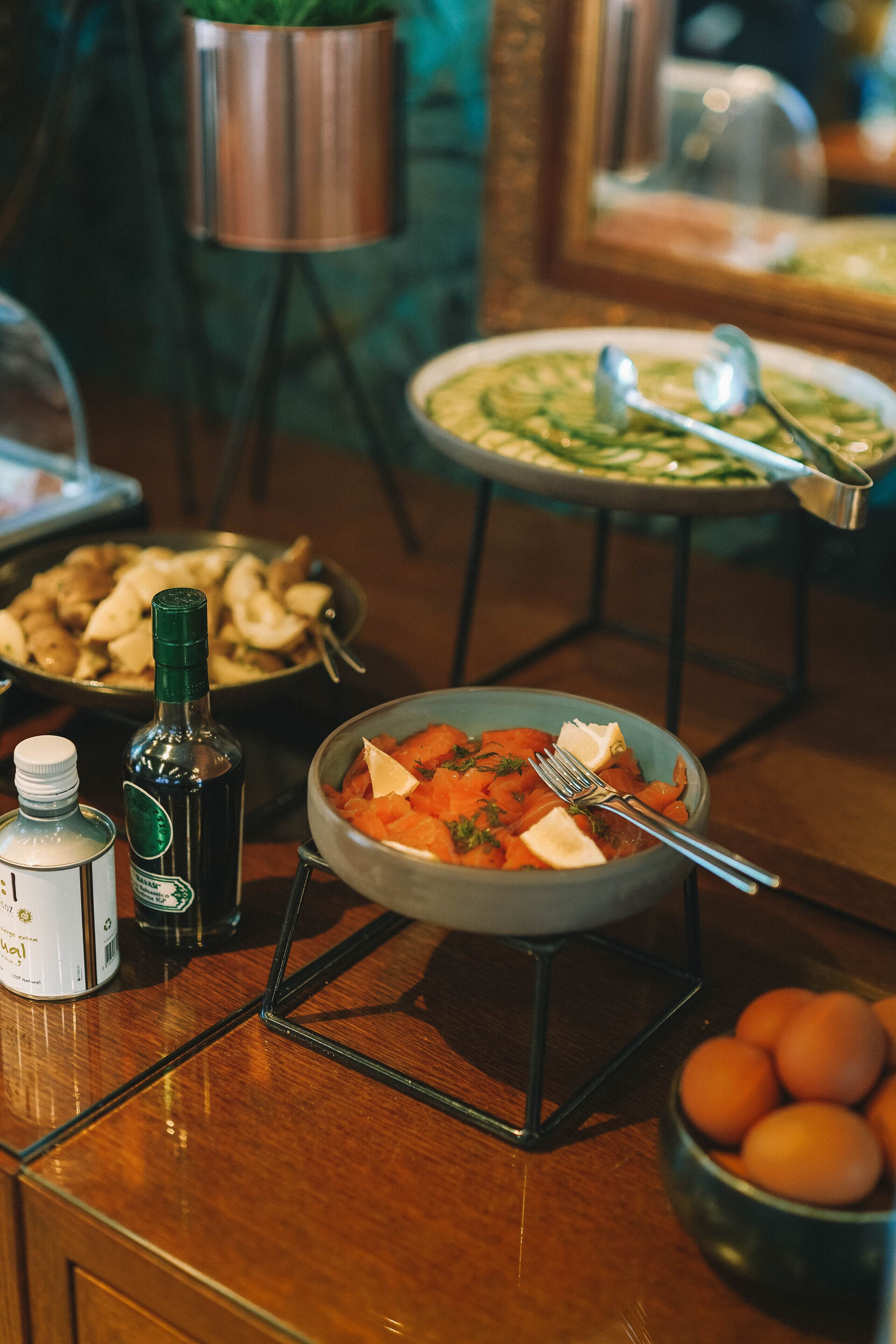 A buffet table with various dishes, including a bowl of carrots and a bowl of eggs.