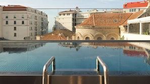 Una piscina al aire libre, sombrillas, tumbonas