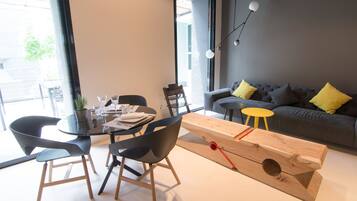 A modern living room with a grey sofa, a wooden coffee table, and black chairs.