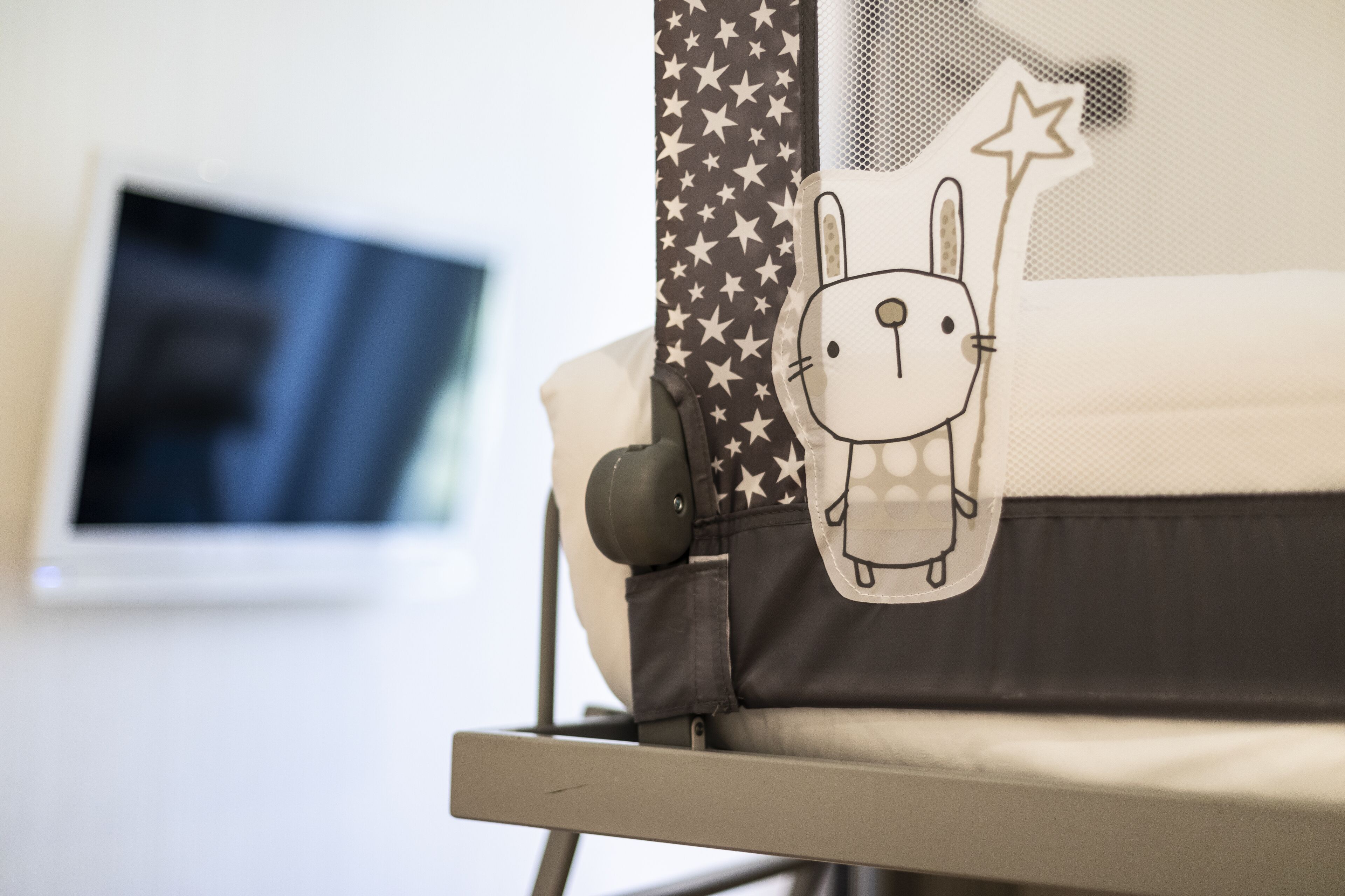 Un cochecito de bebé con tela estampada de estrellas y un sticker de un conejo de dibujos animados.