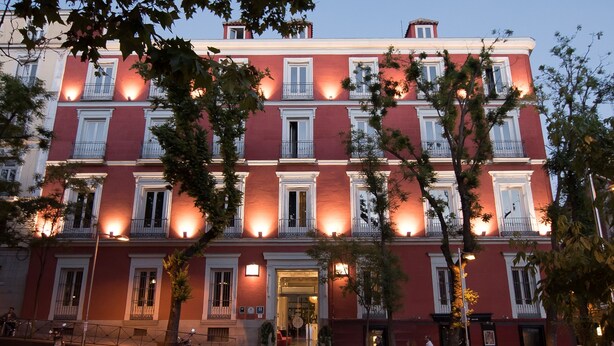 A red building with multiple balconies and a central entrance. - Petit Palace Santa Bárbara (Madrid)