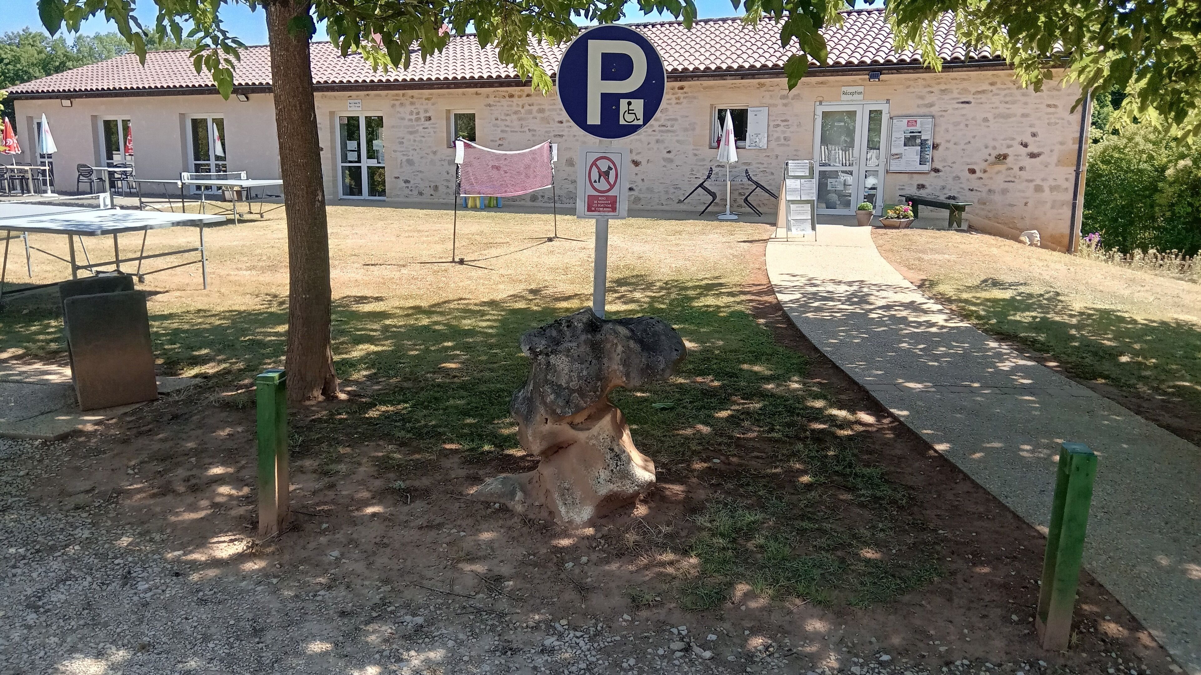 A parking sign, a reception building, and outdoor seating.