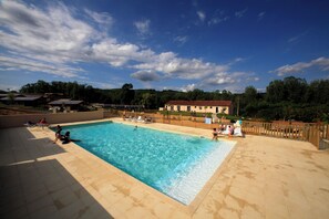 A rectangular swimming pool with clear blue water, surrounded by a wooden fence and a tiled deck. - Terres de France - Les Hameaux de Pomette (Marminiac)