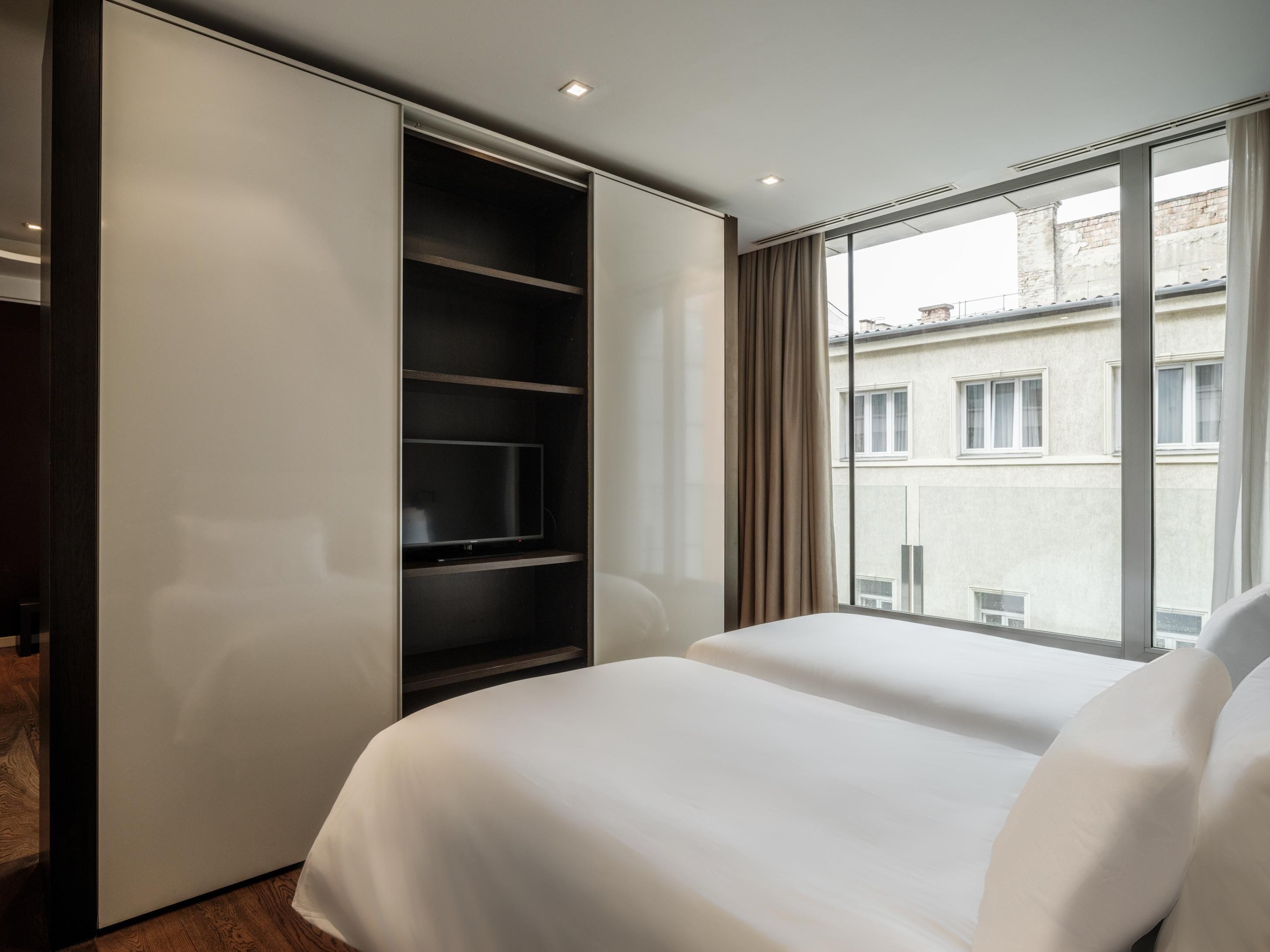 A hotel room with a bed, a wardrobe, and a TV.