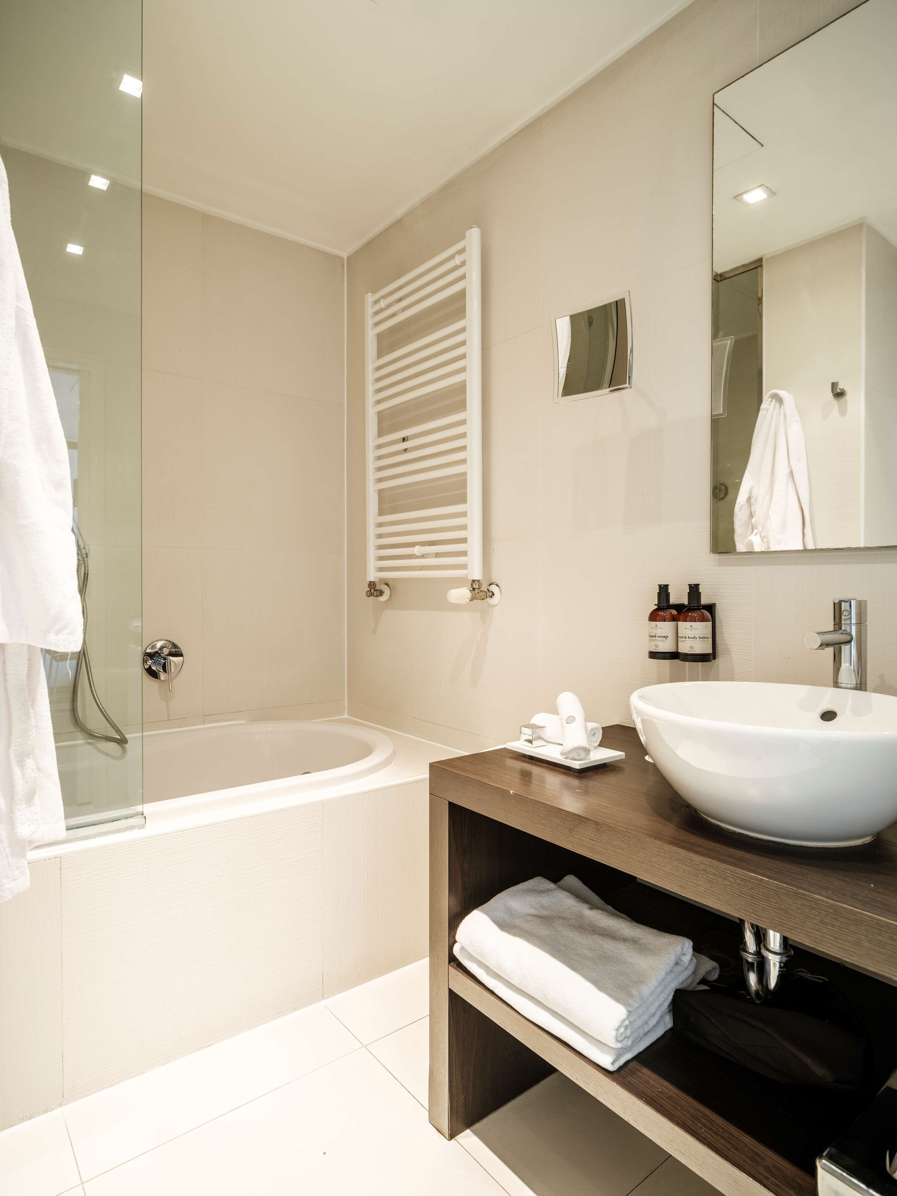 A modern bathroom with a bathtub, a sink, and a vanity.