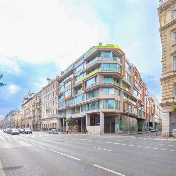 Un hôtel à plusieurs étages, doté d’une architecture moderne, avec des balcons, de grandes fenêtres et une entrée imposante.