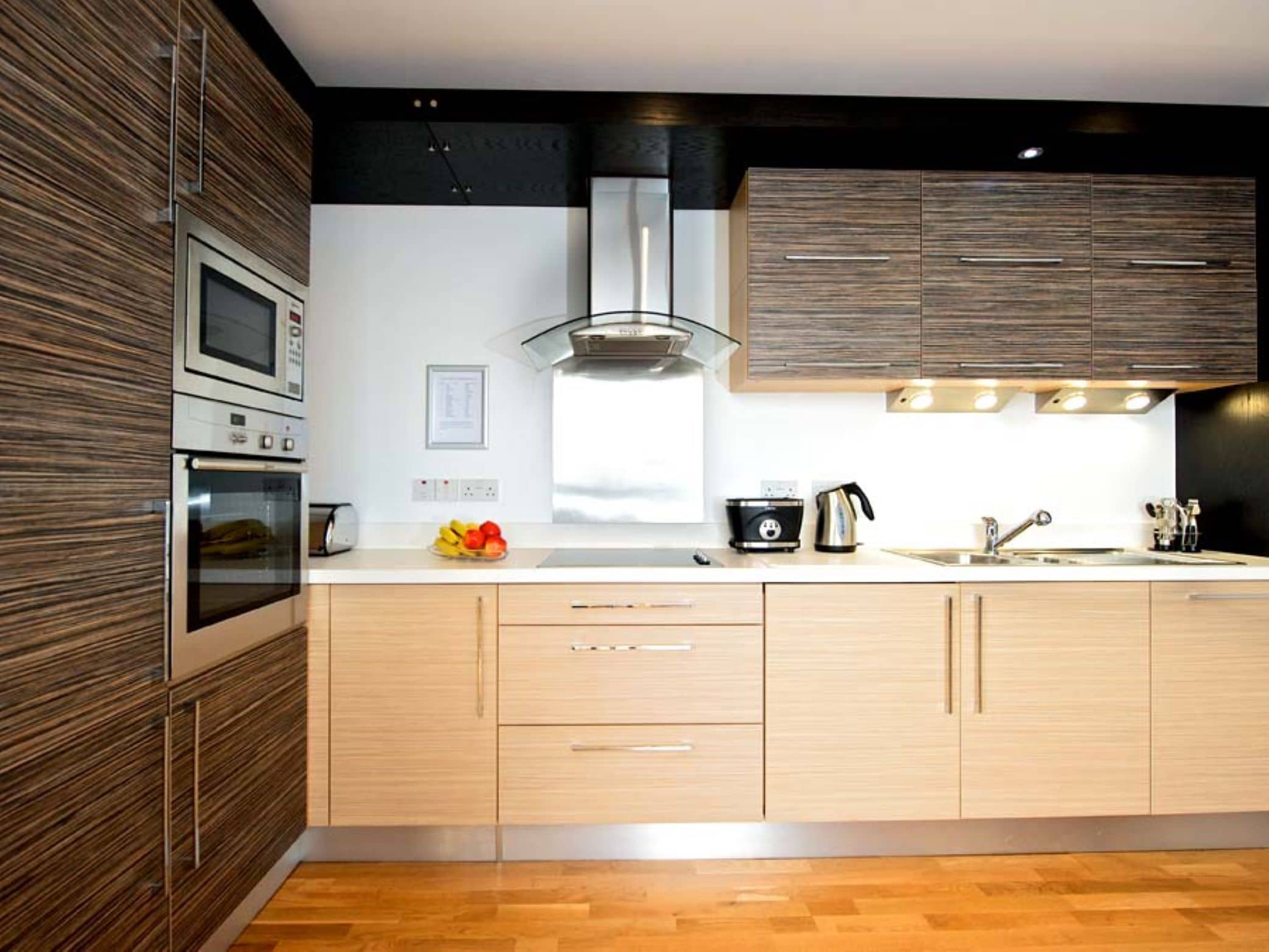 A modern kitchen with built-in appliances, wooden cabinetry, and a central island.