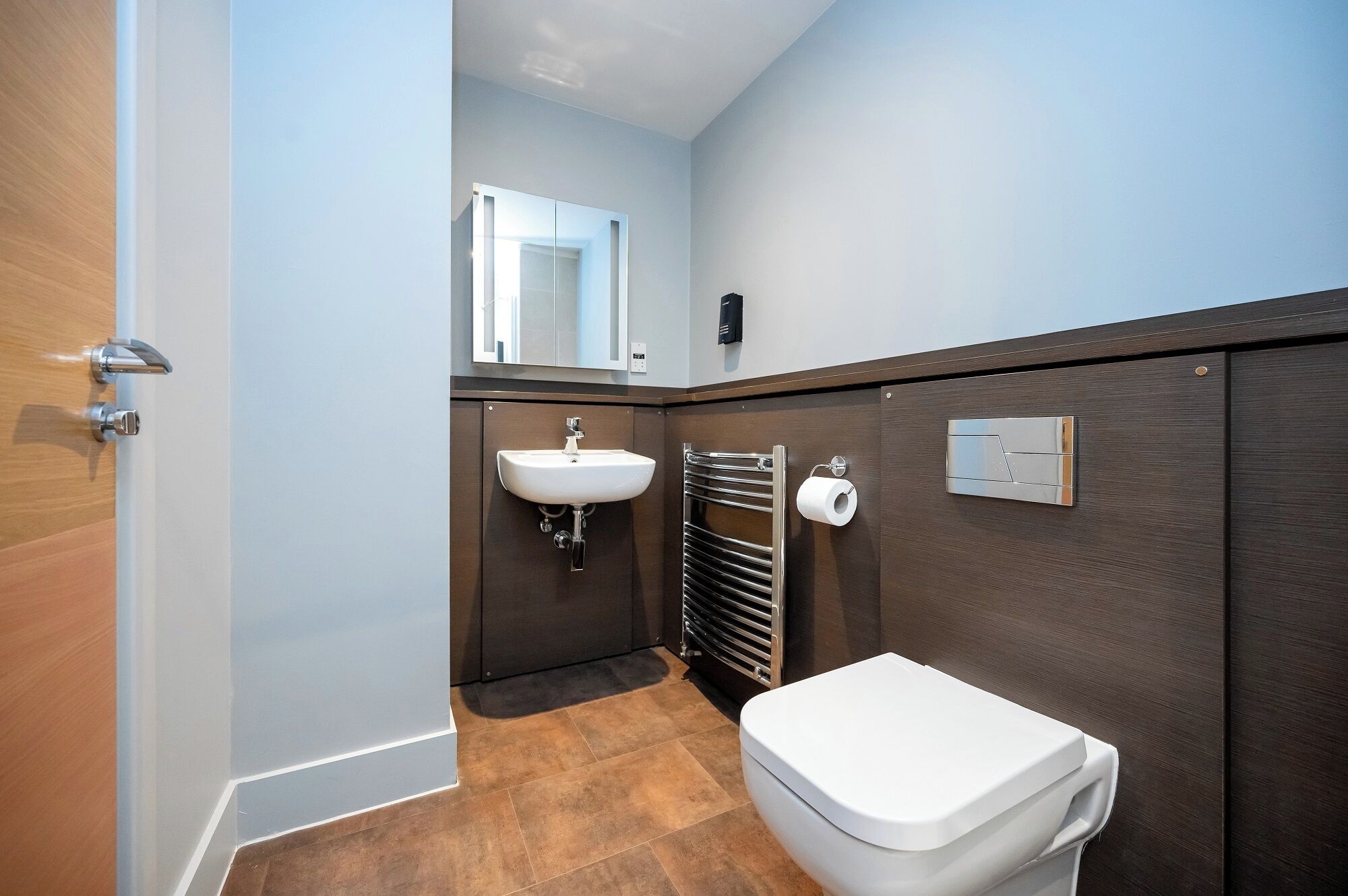 A bathroom with a white sink, a toilet, and a towel rack.