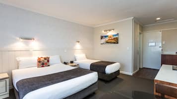 Escritorio, cortinas blackout y tabla de planchar con plancha