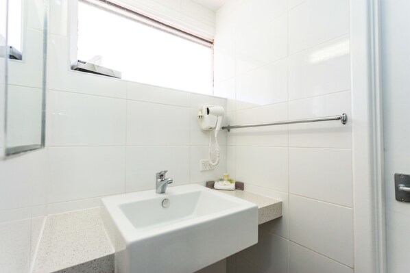 A bathroom with a white sink, a towel rack, and a mirror.