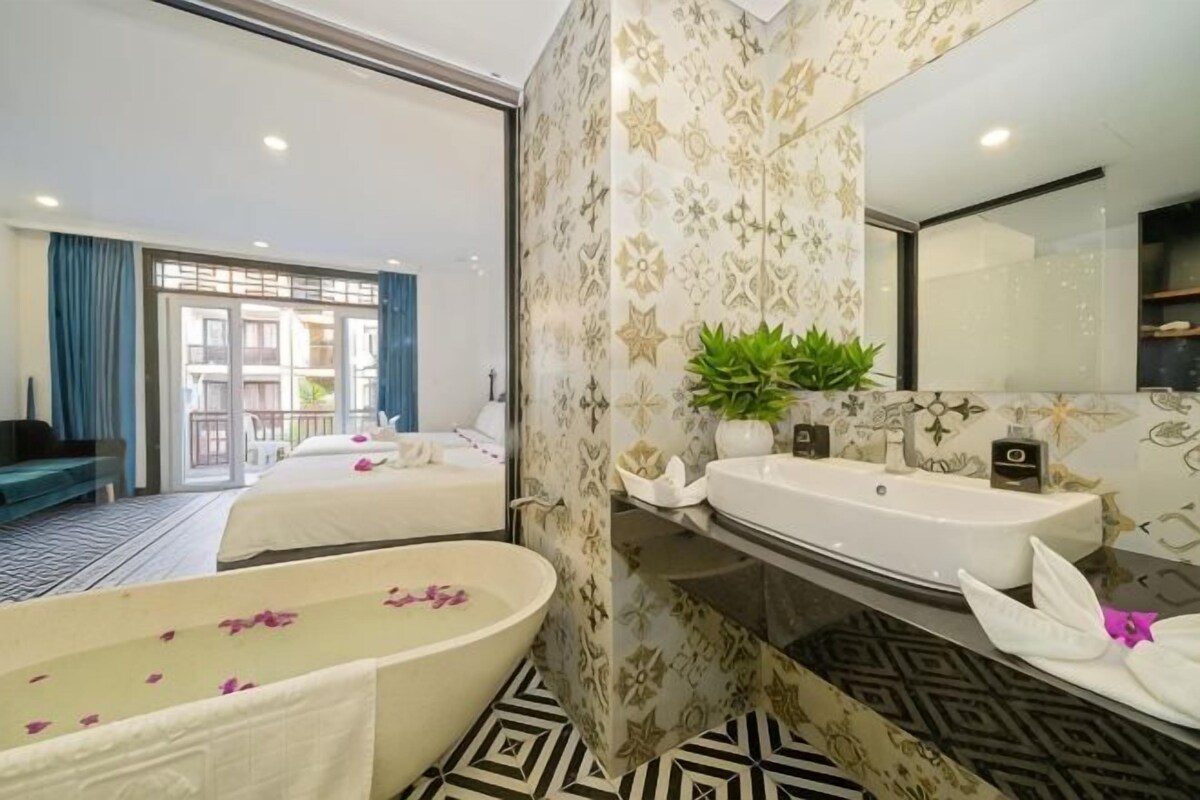 A modern bathroom with a bathtub, two sinks, and a large mirror.