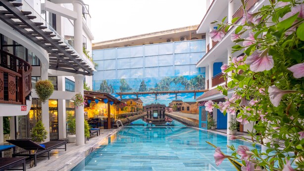 Una piscina interior con sillas de descanso y un mural de fondo.