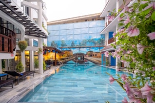 Una piscina interior con sillas de descanso y un mural de fondo.