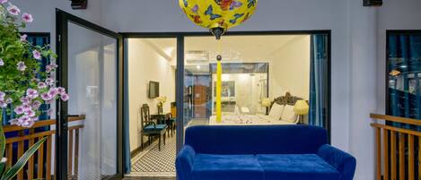 A room with a blue sofa, patterned floor, and a large decorative globe.