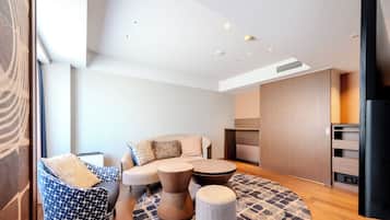 A modern living room with a sofa, two ottomans, and a coffee table.
