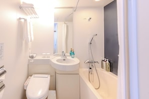 Et moderne badeværelse med toilet, vask og badekar.