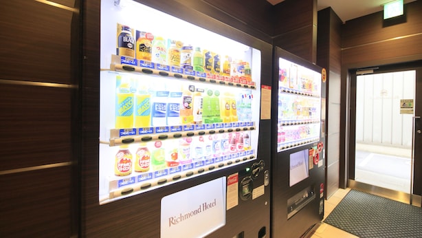 Máquina expendedora con bebidas y aperitivos, ubicada en el vestíbulo de un hotel.