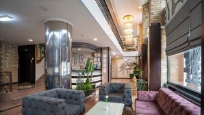 A lobby with a reception desk, seating area, and a staircase. - Buyuk Velic Hotel (Gaziantep)