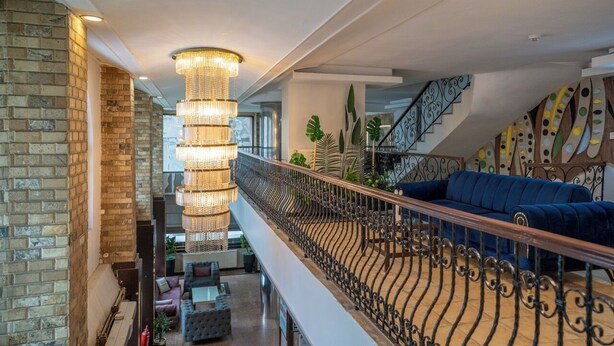 A multi-level interior with a staircase, a chandelier, and a blue sofa. - Buyuk Velic Hotel (Gaziantep)