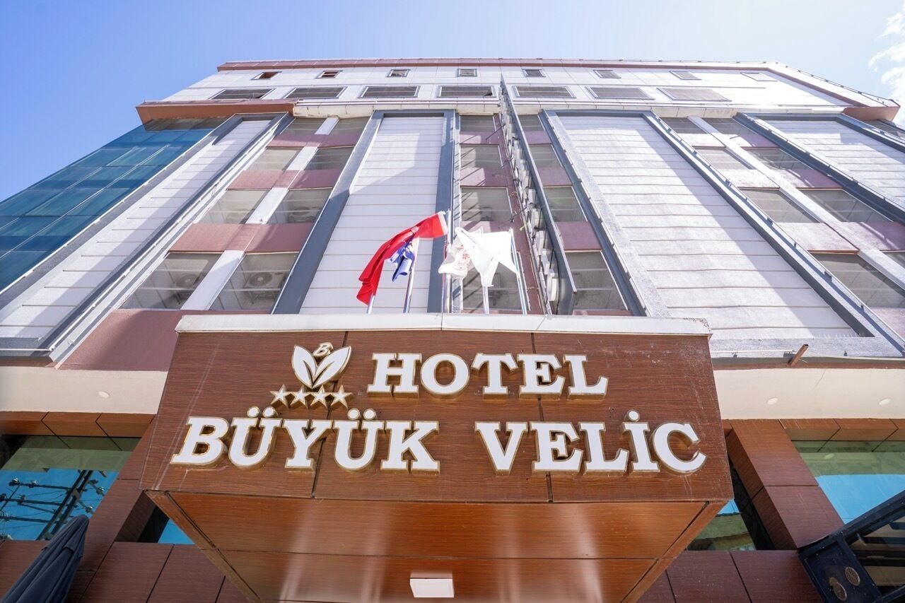 A hotel sign with the name 'HOTEL BUYUK VELIC' and a flag.