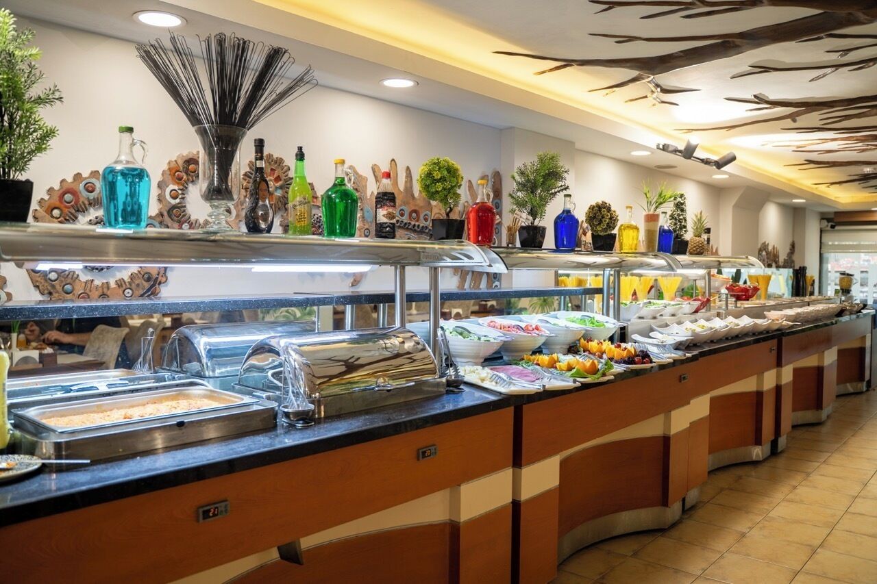 Un bufé con diversas opciones de comida y una selección de bebidas.