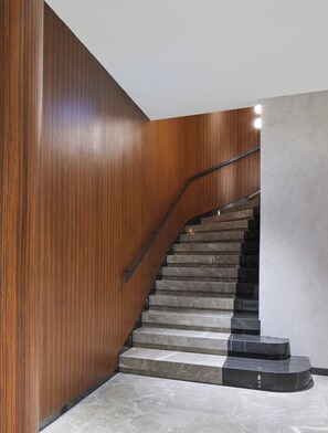 A staircase with wooden paneling on one side and a plain wall on the other, leading to an upper floor. - Lamartine Hotel (Istanbul)