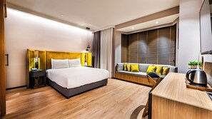 Ein modernes Hotelzimmer mit einem großen Bett, einem Schreibtisch und einem Fenster mit Jalousien.