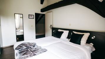 Een slaapkamer met een groot bed, een spiegel en een kledingkast.