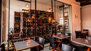 A wine cellar with numerous wine racks and a few tables with chairs. - Hotel Den Grooten Wolsack (Mechelen)