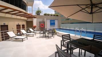 Alberca al aire libre y camastros