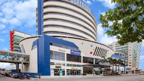 Un hôtel moderne à la façade incurvée, doté de plusieurs étages et d’une enseigne bien visible indiquant « TRYP GUAYAQUIL ».