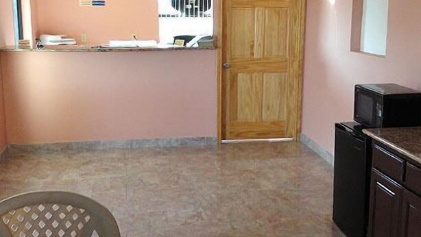 Una cocina con puerta de madera, microondas y refrigerador.
