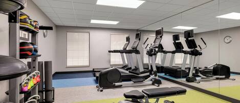 A gym with treadmills, elliptical machines, and weightlifting equipment.