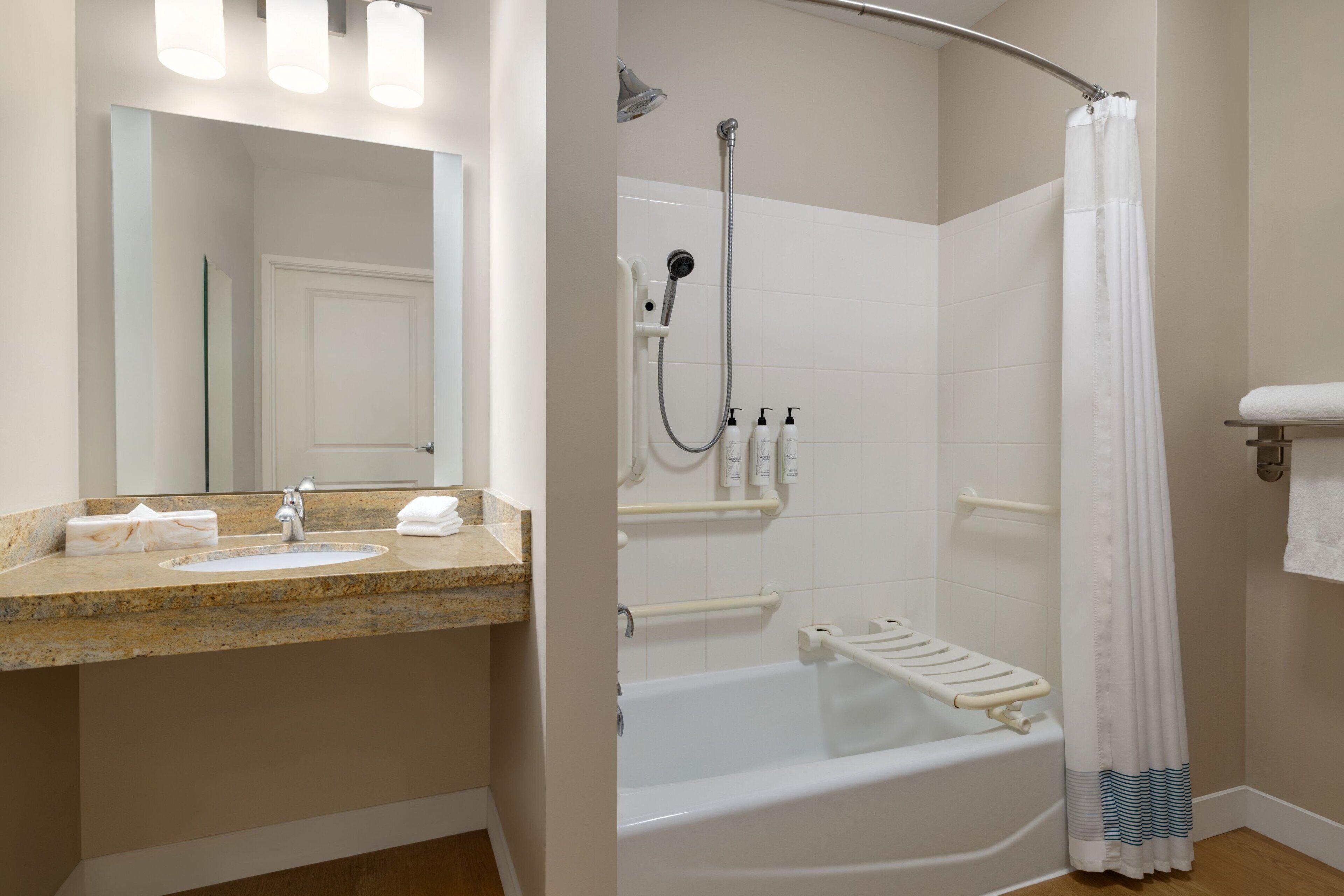 Une salle de bain équipée d’un lavabo, d’un miroir, d’une douche et d’une baignoire.