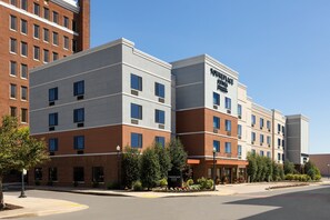 Een meerlaags hotel met een modern ontwerp, met een combinatie van baksteen en glad stucwerk aan de buitenkant, en een opvallend bord met 'Townplace Suites' aan de gevel.