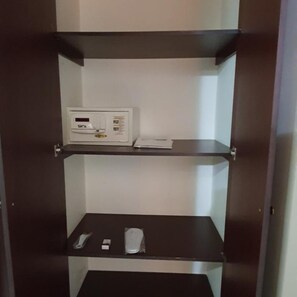 A room with a built-in microwave on the upper shelf and a remote control and a small item on the lower shelf. - Ivory Hotel Apartments (Abu Dhabi)
