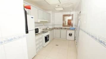 Een koelkast met diepvriezer, een microgolfoven, een oven