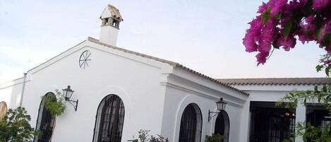 Un edificio blanco con ventanas arqueadas y techo de tejas.