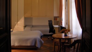 A hotel room with a bed, a desk, a chair, and a small table. - Alla Stazione (Trieste)