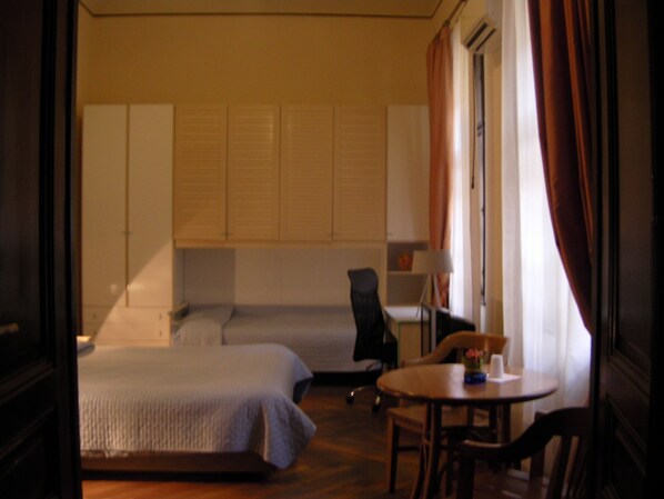 Una habitación de hotel con cama, escritorio, silla y una pequeña mesa.
