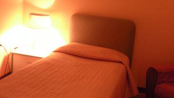 Una habitación con una cama, una lámpara y un adorno en la pared.